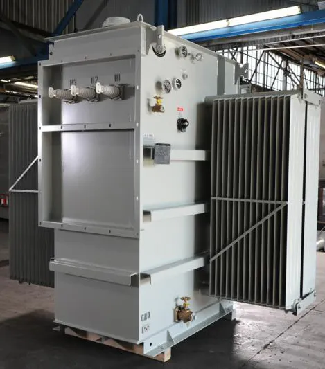 Industrial power transformer with cooling radiator in factory warehouse setting