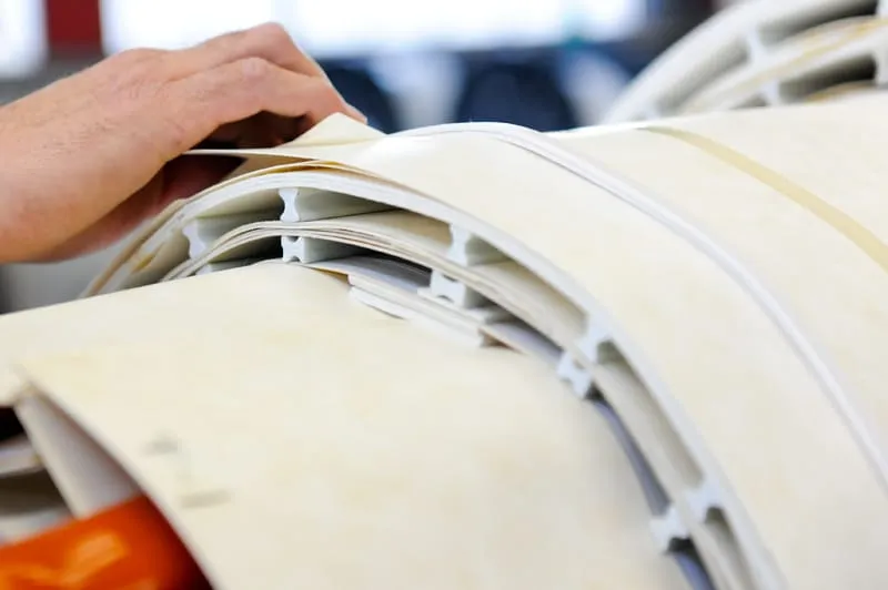 Hand flipping through stack of white transformer products in gallery display