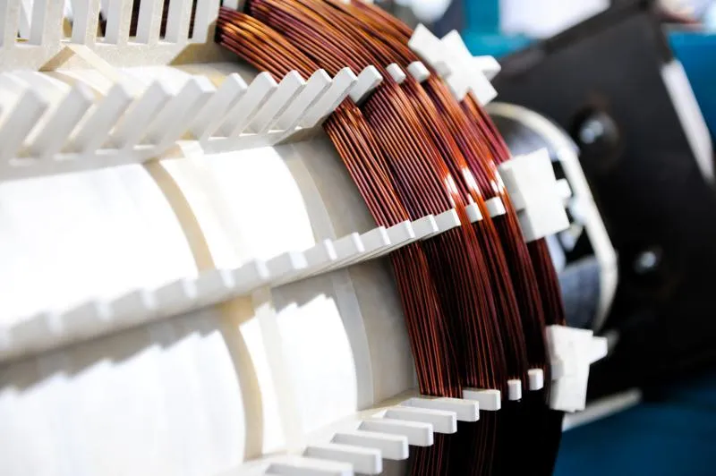 Electric motor coil windings with white insulation and copper wire in transformer assembly