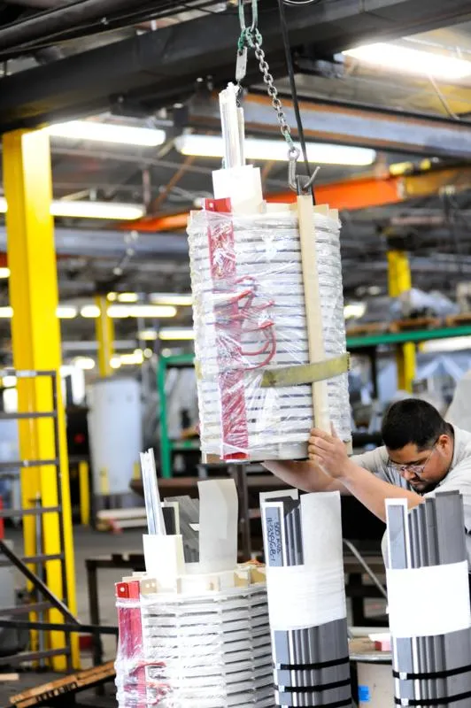 Worker assembles transformer coil components in industrial manufacturing facility