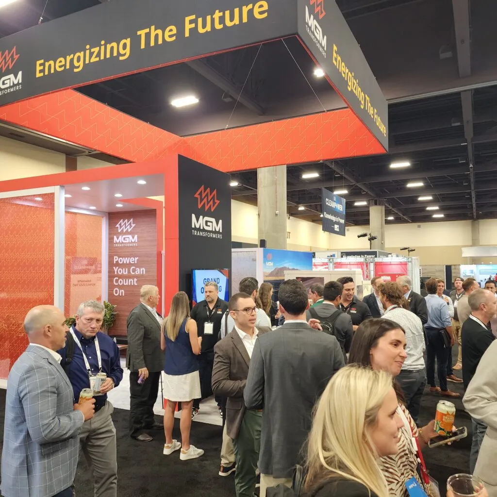 MGM Transformers booth at ACP 2025 conference with attendees networking under "Energizing The Future" signage