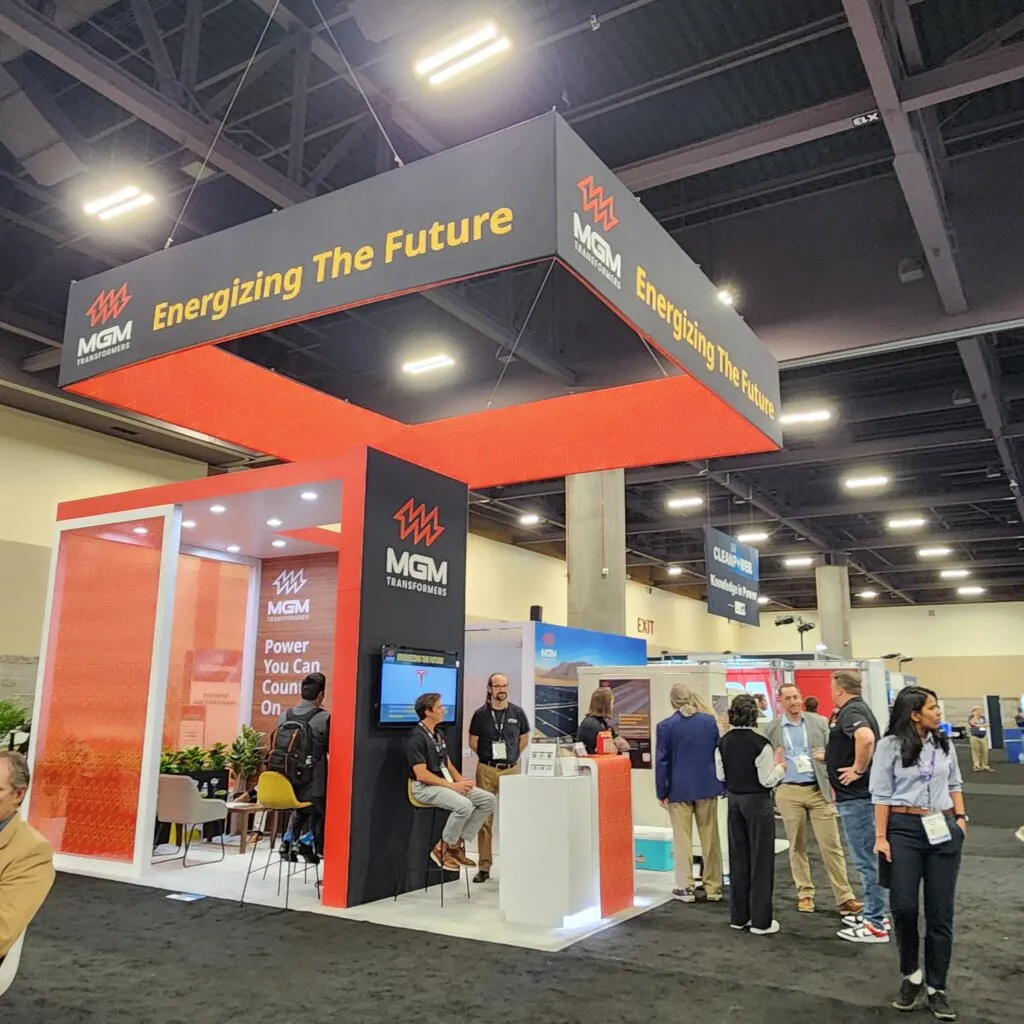 MGM Transformers booth at ACP 2025 conference with "Energizing The Future" signage and visitors exploring displays
