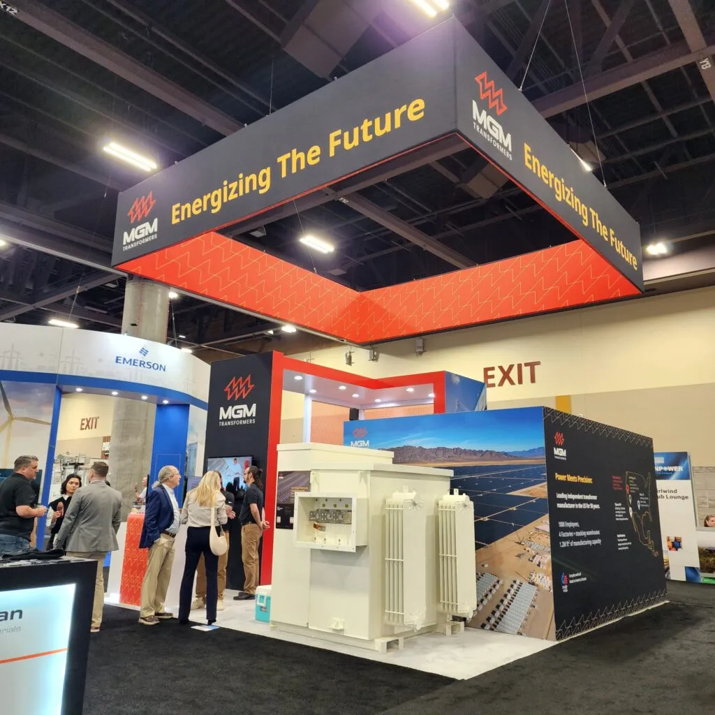MGM Transformers booth at ACP 2025 conference displaying transformers and solar energy solutions with "Energizing The